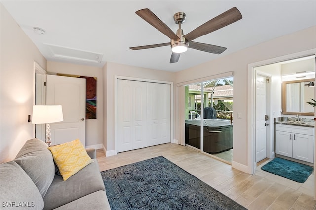 living room with ceiling fan, sink, and light hardwood / wood-style floors