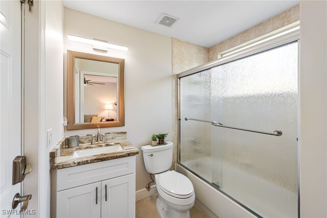 full bathroom featuring ceiling fan, vanity, bath / shower combo with glass door, and toilet