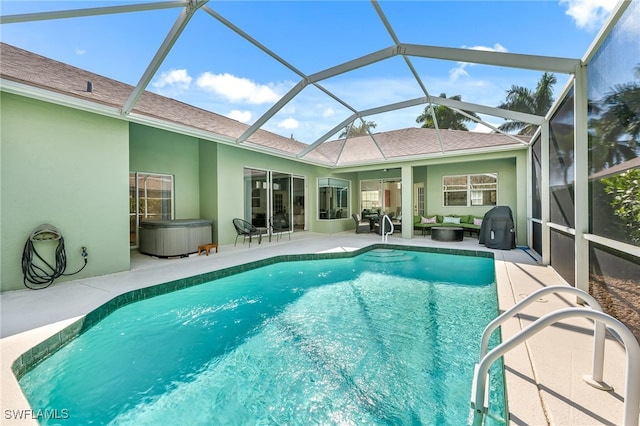 view of swimming pool featuring a patio area, ceiling fan, glass enclosure, and a hot tub