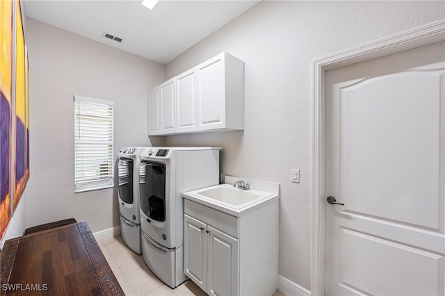 clothes washing area with cabinets, light tile patterned floors, separate washer and dryer, and sink