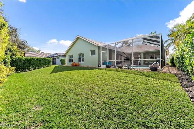 back of property featuring a lanai and a lawn