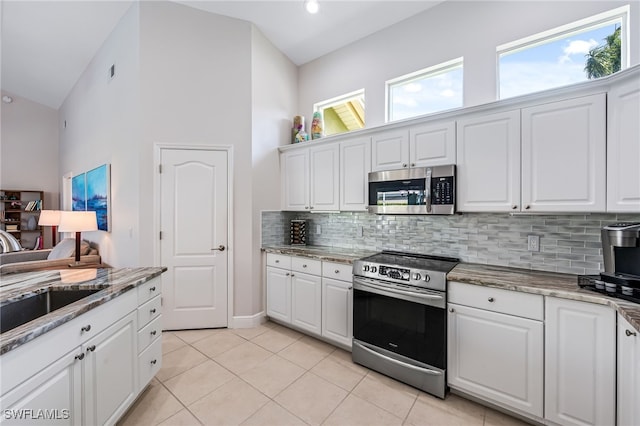 kitchen with a wealth of natural light, white cabinetry, and appliances with stainless steel finishes