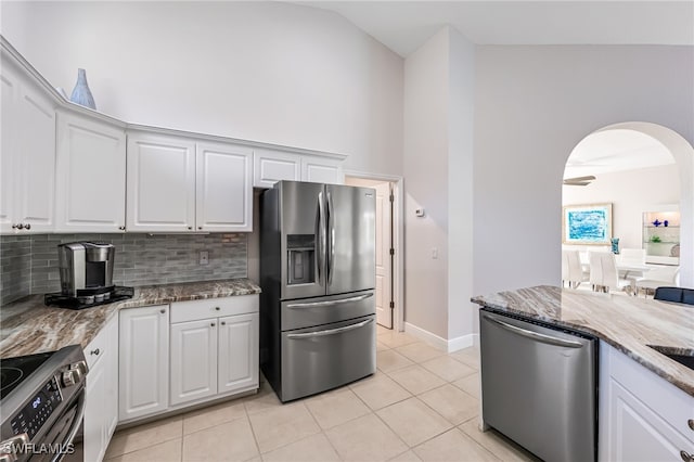 kitchen with light stone countertops, white cabinetry, appliances with stainless steel finishes, and tasteful backsplash