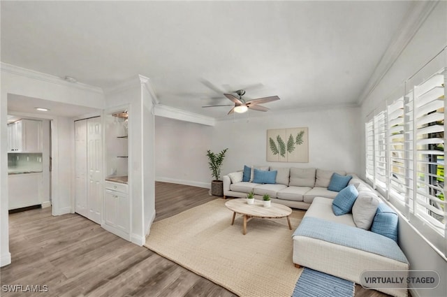 living room with ceiling fan, light wood-type flooring, and ornamental molding