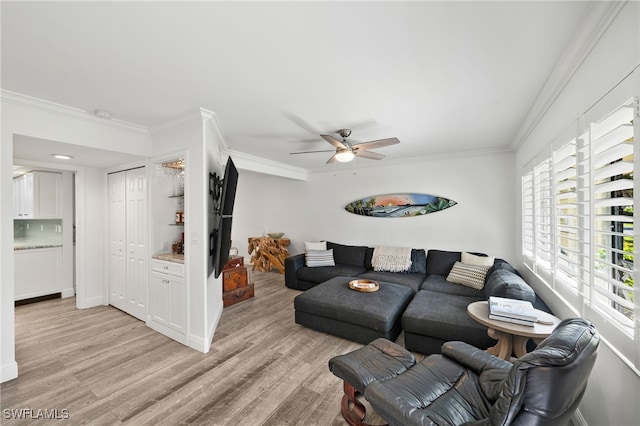 living room featuring light hardwood / wood-style flooring, ceiling fan, and crown molding