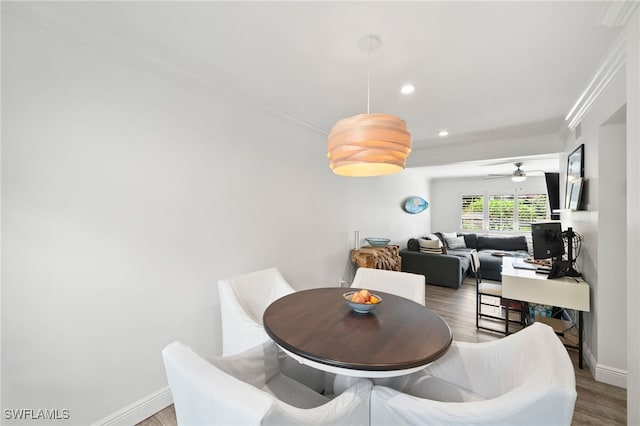 dining area with wood-type flooring, ceiling fan, and crown molding