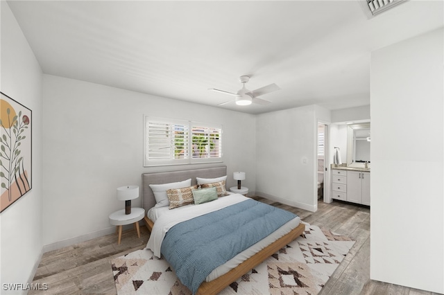 bedroom featuring ceiling fan, ensuite bathroom, and light hardwood / wood-style floors