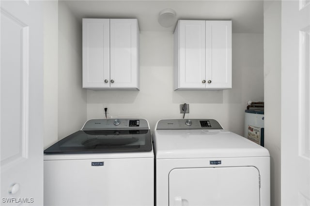 washroom featuring cabinets, washer and dryer, and water heater