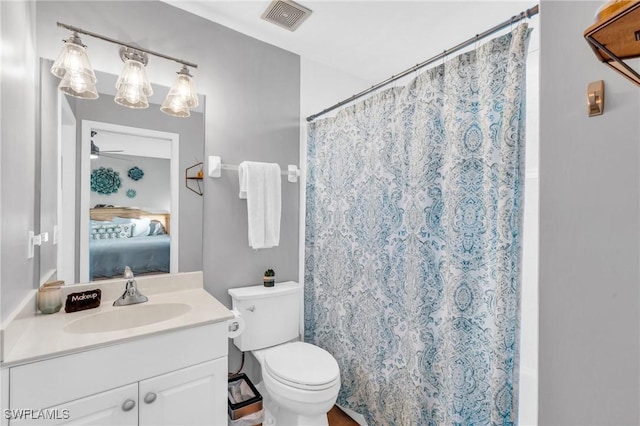 bathroom with curtained shower, ceiling fan, vanity, and toilet