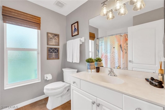 bathroom with tile patterned flooring, vanity, toilet, and walk in shower