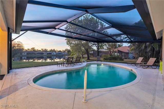 pool at dusk featuring a patio and glass enclosure