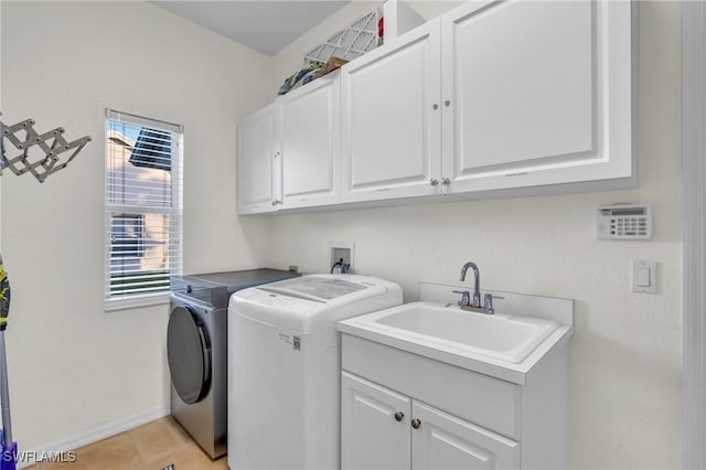 washroom with cabinets, sink, light tile patterned floors, and washer and dryer