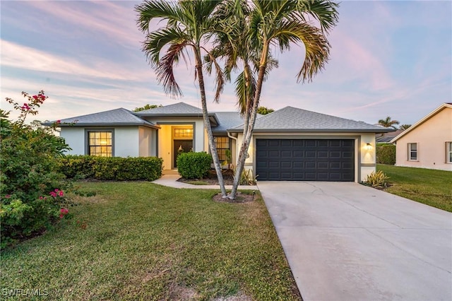 view of front of home with a lawn and a garage