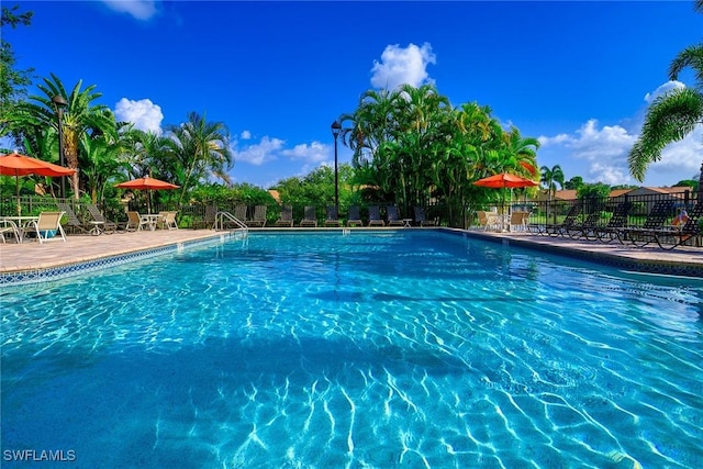 pool with a patio and fence