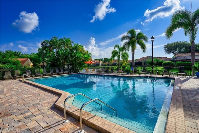 pool with a patio and fence