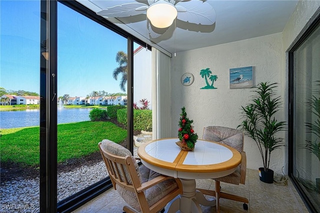 sunroom featuring a water view