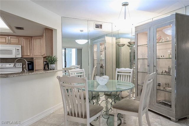 dining room featuring light tile patterned floors, visible vents, and baseboards