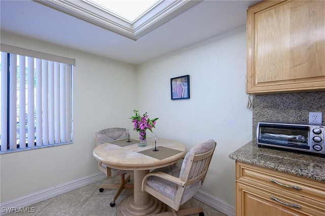 dining area with light tile patterned flooring, a toaster, and baseboards