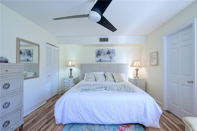 bedroom with a closet, visible vents, light wood-style flooring, and a ceiling fan