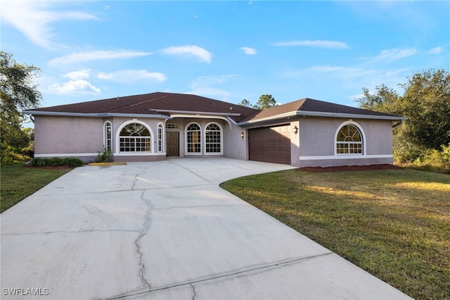 view of front of property with a front yard and a garage