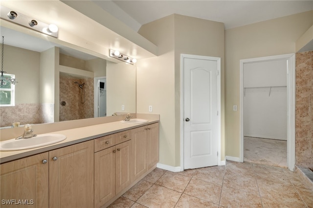 bathroom with tile patterned floors, vanity, and a tile shower