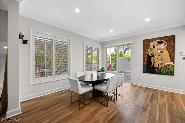 dining space with hardwood / wood-style floors and ornamental molding