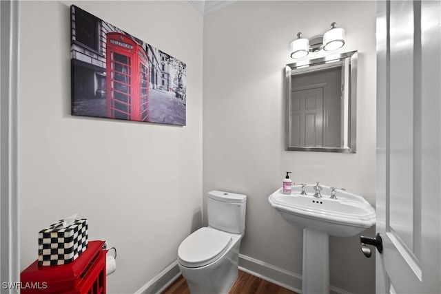 bathroom with sink, toilet, and hardwood / wood-style flooring