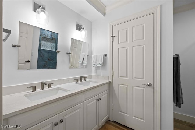 bathroom featuring vanity, wood-type flooring, and ornamental molding