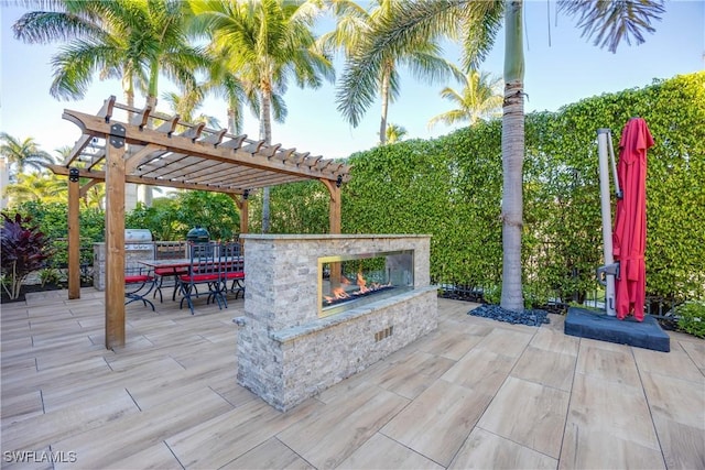 view of patio / terrace with a pergola and an outdoor stone fireplace