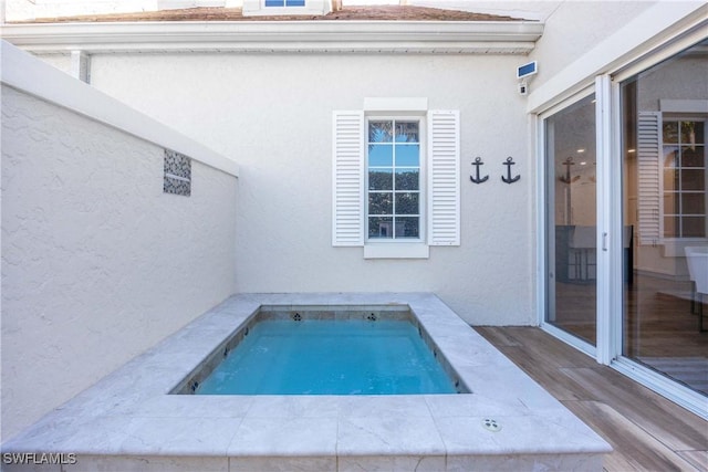 view of pool with a hot tub