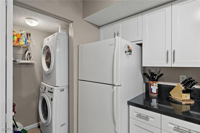 laundry area with stacked washer / dryer and a textured ceiling