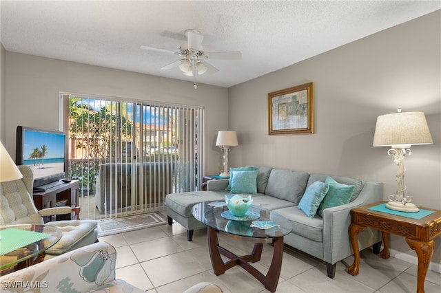 living room featuring ceiling fan, light tile patterned floors, and a textured ceiling