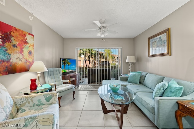 living room with ceiling fan, light tile patterned flooring, and a textured ceiling