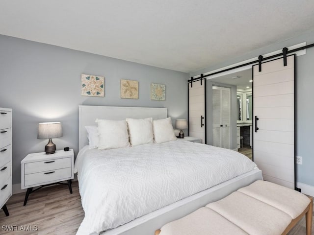 bedroom with a closet, hardwood / wood-style flooring, and a barn door