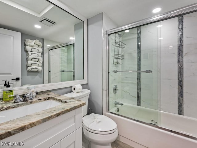 full bathroom featuring vanity, shower / bath combination with glass door, and toilet