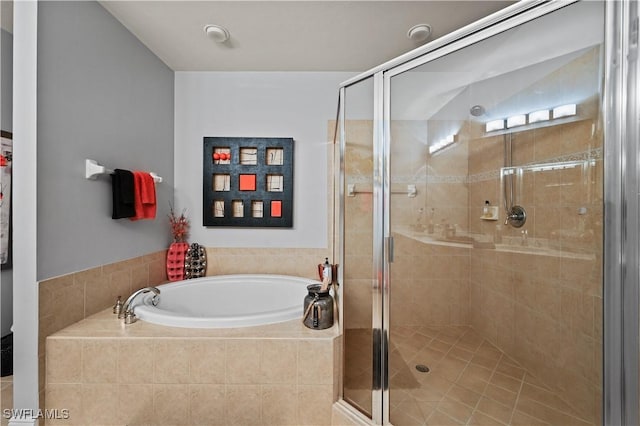 bathroom featuring a garden tub and a shower stall