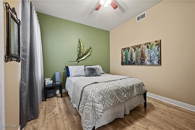 bedroom featuring visible vents, ceiling fan, light wood-style flooring, and baseboards