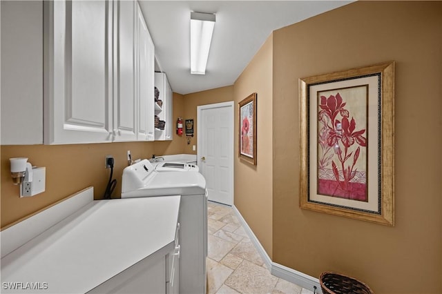 washroom with baseboards, cabinet space, independent washer and dryer, and stone tile floors