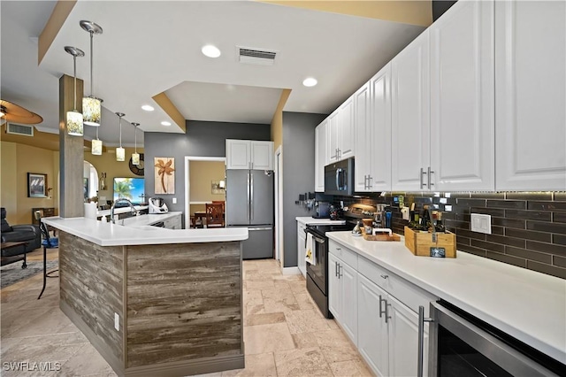 kitchen with white cabinets, light countertops, hanging light fixtures, freestanding refrigerator, and black electric range oven