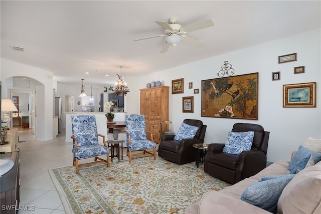 tiled living room featuring ceiling fan with notable chandelier