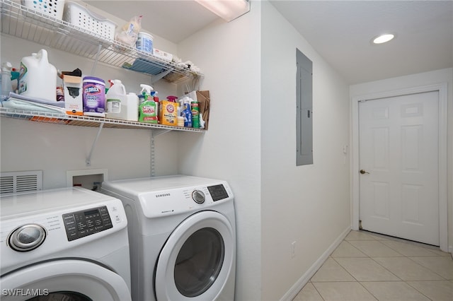 laundry area featuring light tile patterned floors, electric panel, and washing machine and clothes dryer