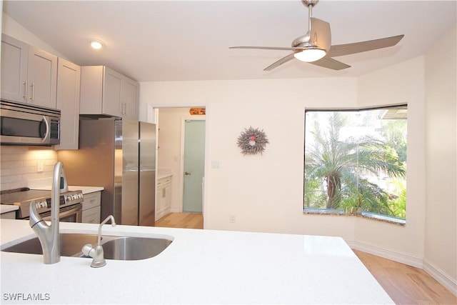 kitchen featuring backsplash, stainless steel appliances, light hardwood / wood-style floors, and sink