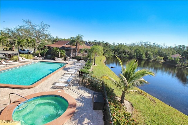 view of pool featuring a community hot tub, a water view, and a patio area