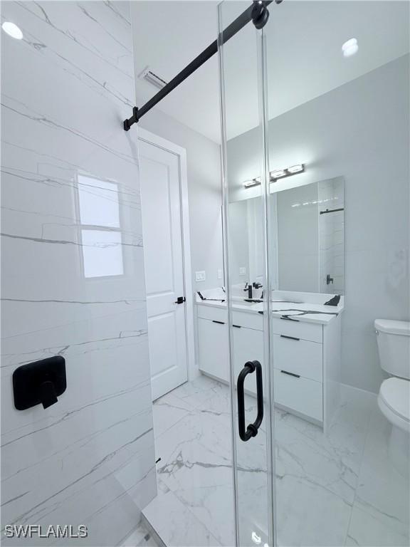 bathroom featuring vanity, toilet, and walk in shower