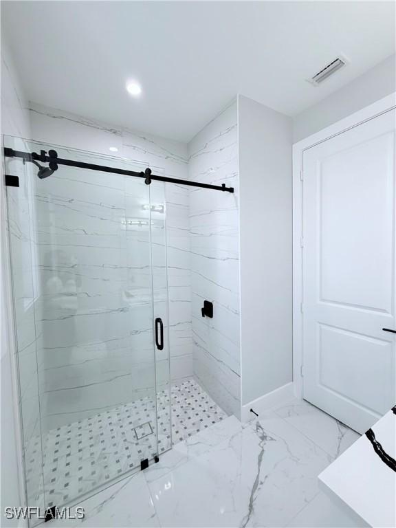 bathroom with a shower with door