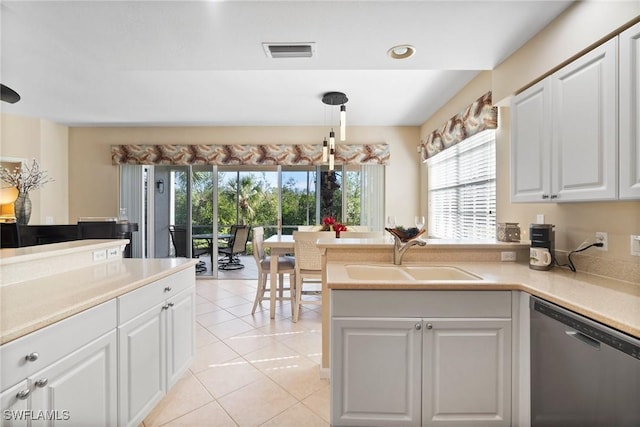 kitchen with hanging light fixtures, stainless steel dishwasher, sink, and white cabinets