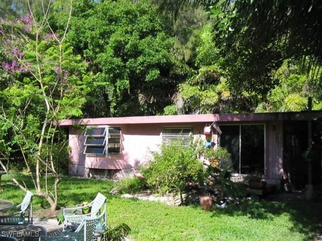 rear view of property featuring a lawn