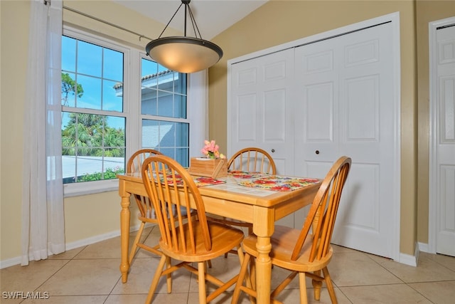 tiled dining room with vaulted ceiling