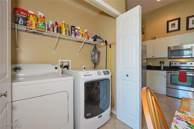 laundry area featuring washer and clothes dryer and light tile patterned floors