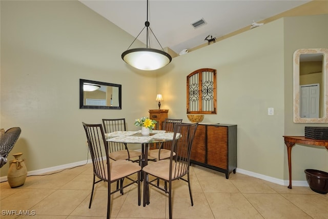 tiled dining room with lofted ceiling